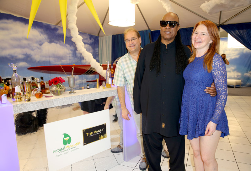 Musician Stevie Wonder (L) poses by the Planes of Fame Museum booth and The Natural Mixologist table at the Grammy Gifting Lounge.
