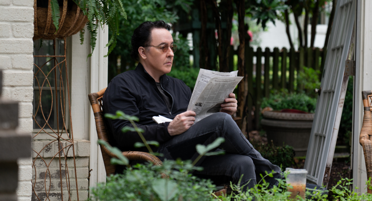 John Cusack reading a newspaper