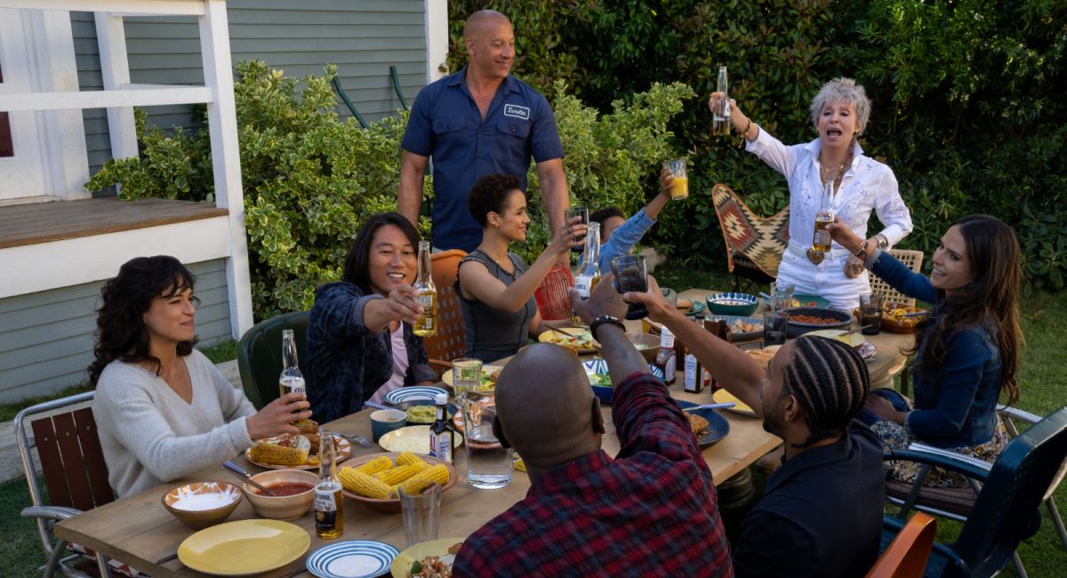 (Clockwise, from left) Letty (Michelle Rodriguez), Han (Sung Kang), Ramsey (Nathalie Emmanuel), Dom (Vin Diesel), Little Brian (Leo Abelo Perry), Abuelita (Rita Moreno), Mia (Jordana Brewster), Tej (Chris ‘Ludacris’ Bridges, back to camera) and Roman (Tyrese Gibson, back to camera) in 'Fast X,' directed by Louis Leterrier.